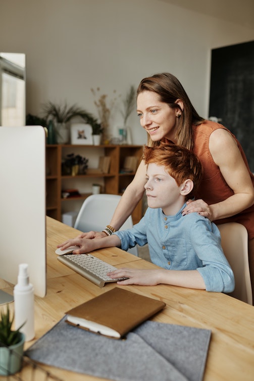 A mother helping her son on the computer